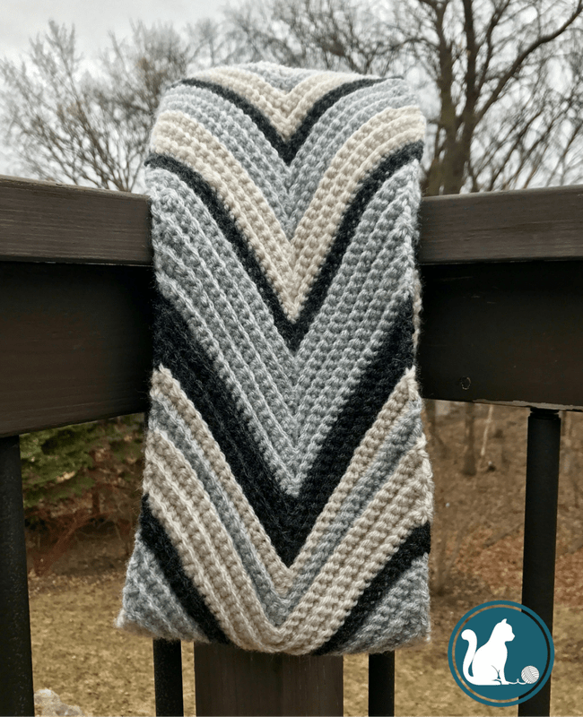 striped chevron crochet scarf hanging off a railing