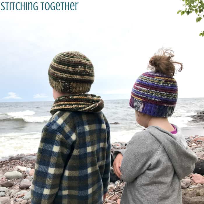 2 kids wearing crochet toddler hats while looking out over the water