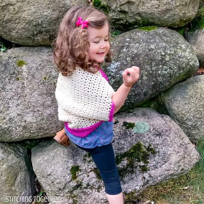 girl showing back of toddler cocoon shrug crochet