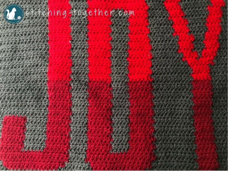 Close up of word Joy in gray crochet background