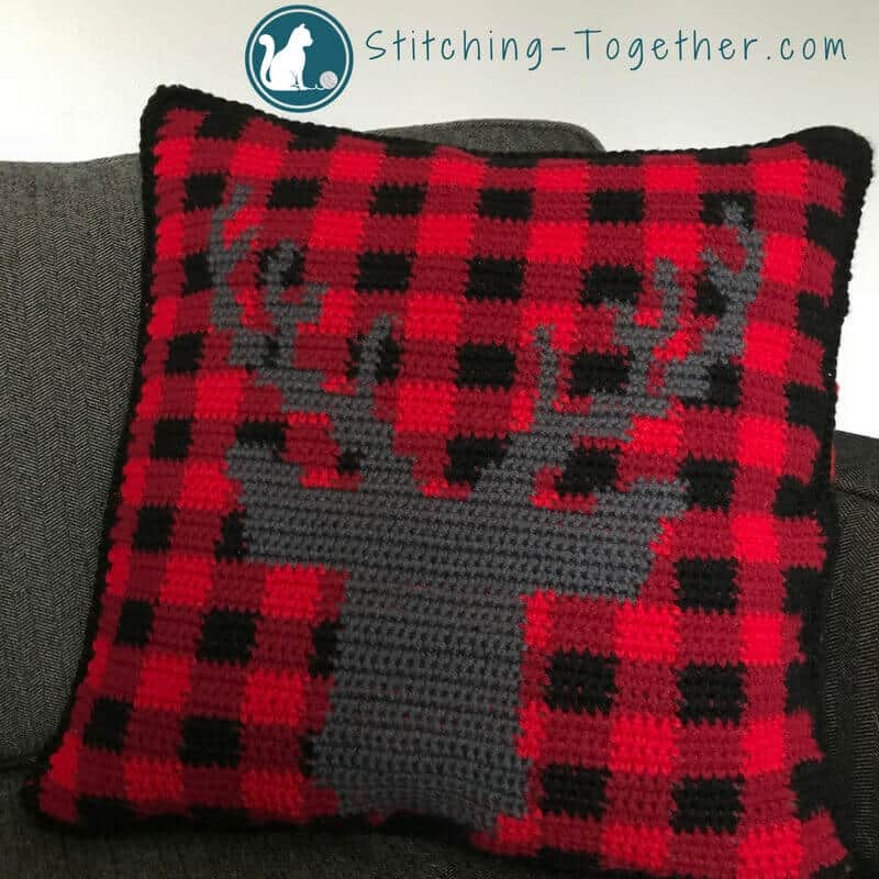 Wow! What a cute buffalo check crochet pillow cover. Get in the holiday spirit with this free crochet pattern. Plaid plus a stag – couldn’t get any trendier. #RHSS #CrochetChristmas #Christmasdecor