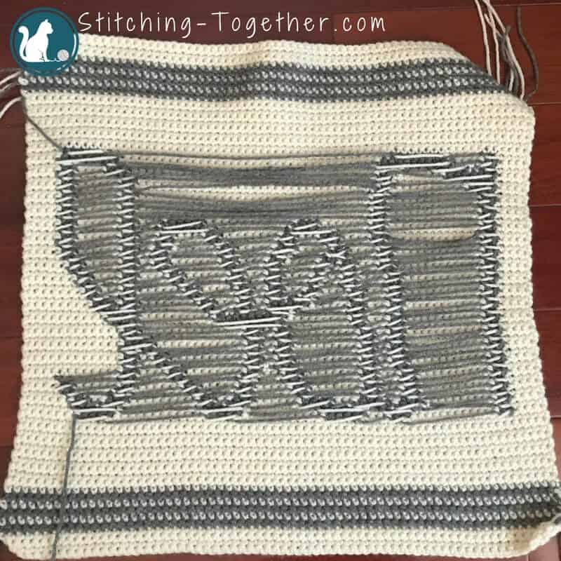 backside of crochet pillow showing yarn