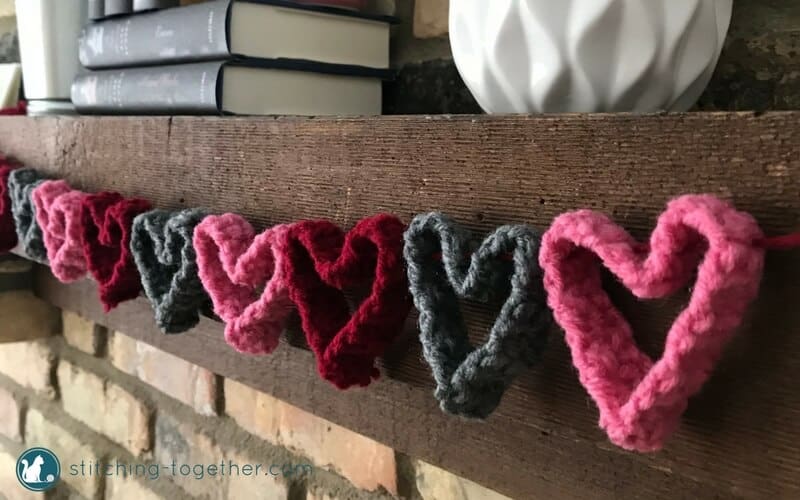 crochet heart garland close up from side hanging on mantel