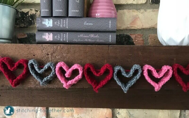 close up of crochet heart garland hanging on mantel