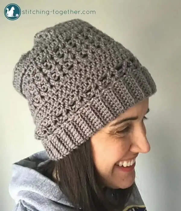 Lady wearing gray crochet slouchy hat with open stitches