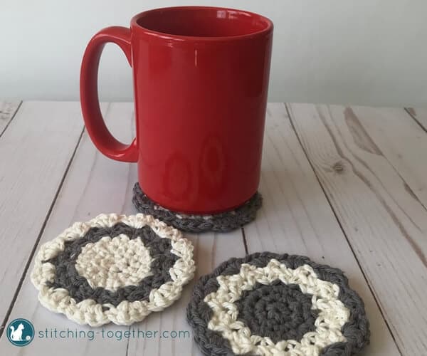 red coffee mug and round crochet coasters