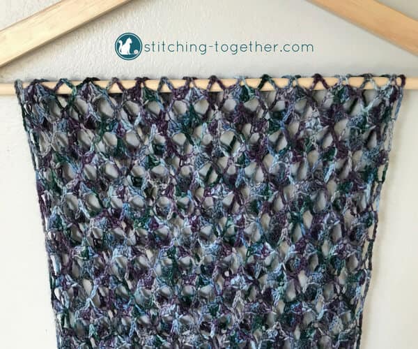 open lacy crochet fabric draped on a hanger