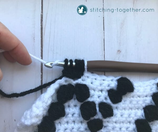 finishing a black bobble stitch on a white background