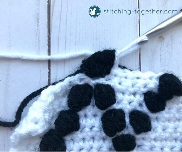 finishing a black bobble stitch on a white background