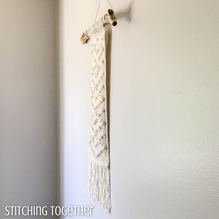 side view of ivory wall hanging with crochet bobbles