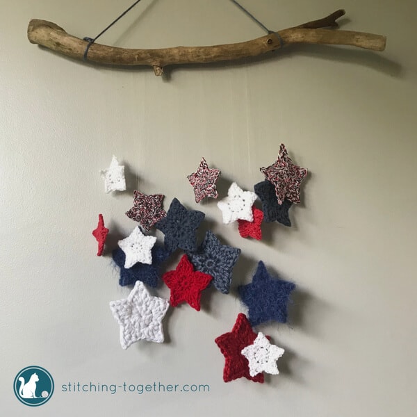 crochet stars hanging from a wood branch