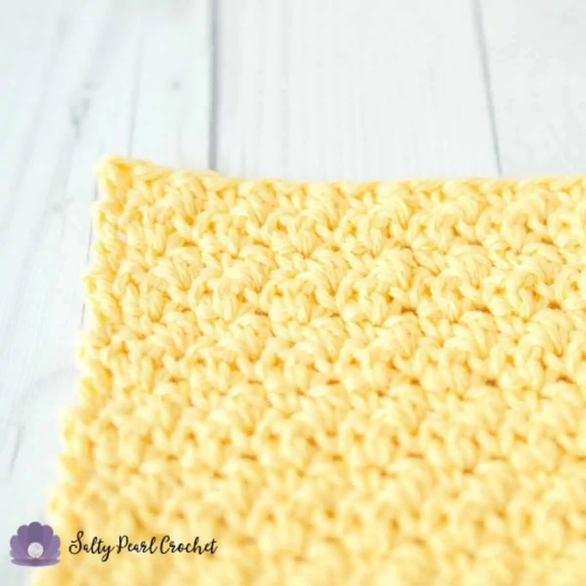 corner of a soft yellow lemon peel dishcloth crochet