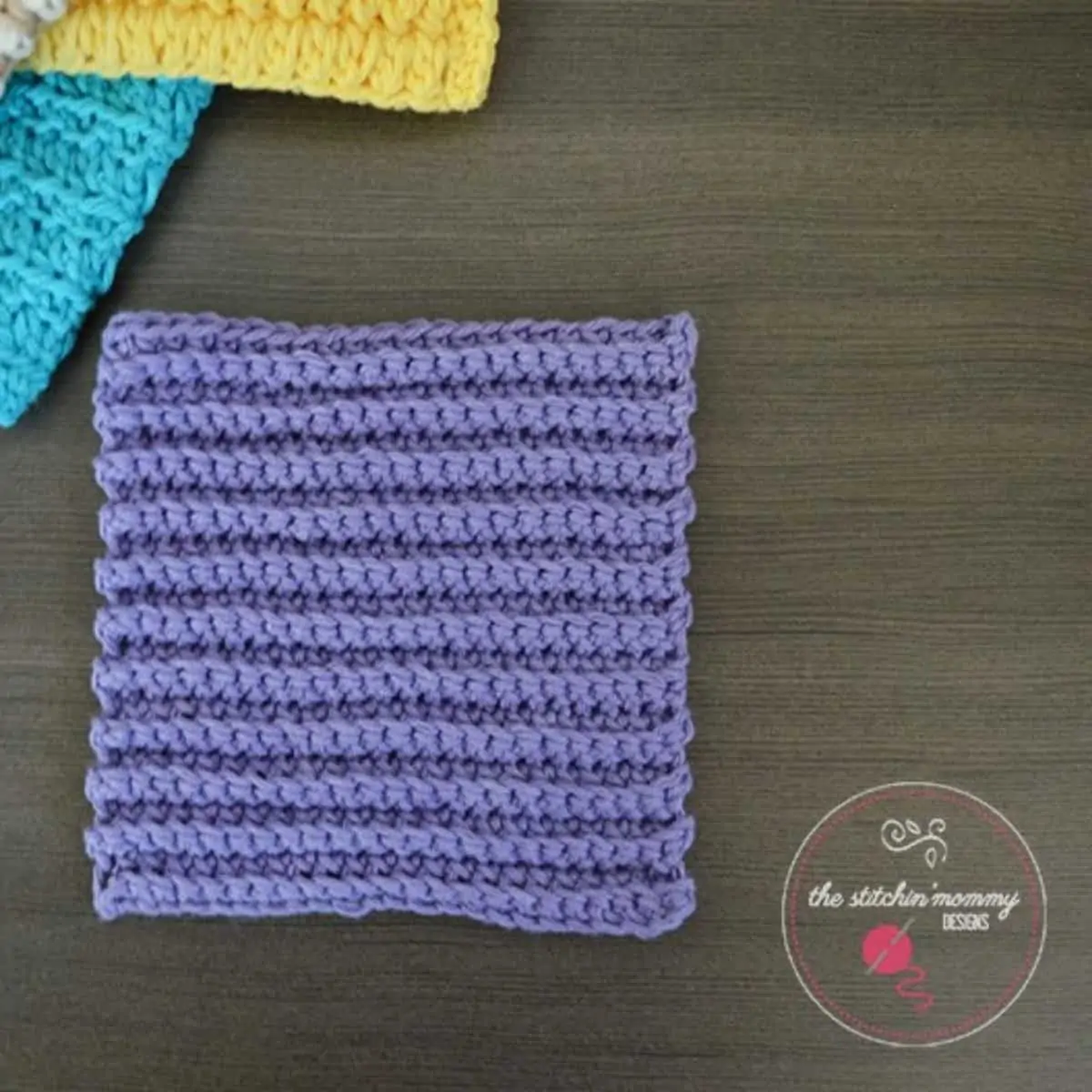 ribbed dishcloth laying flat with other dishcloths peeking from the corner