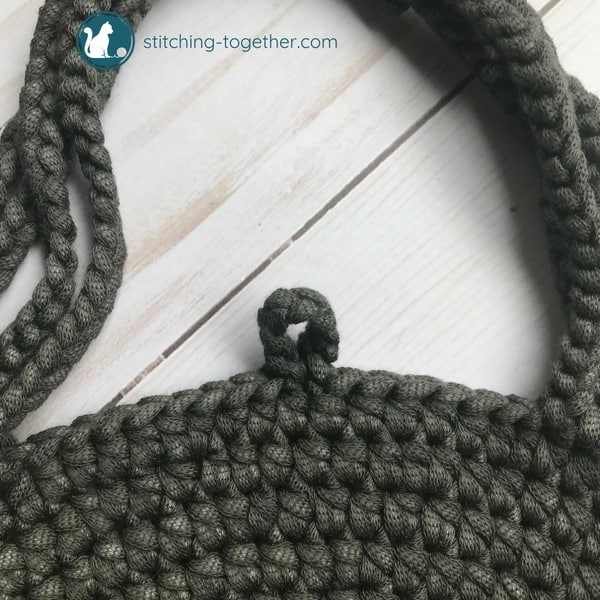 button loop on gray circle bag