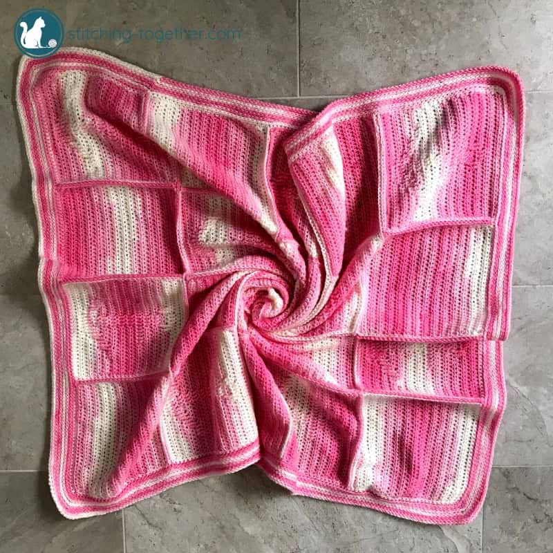 pink crochet blanket on the ground