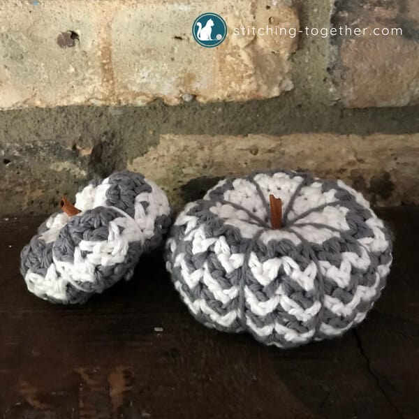 two gray and white crochet pumpkins - a mini crochet pumpkin and a small crochet pumpkin