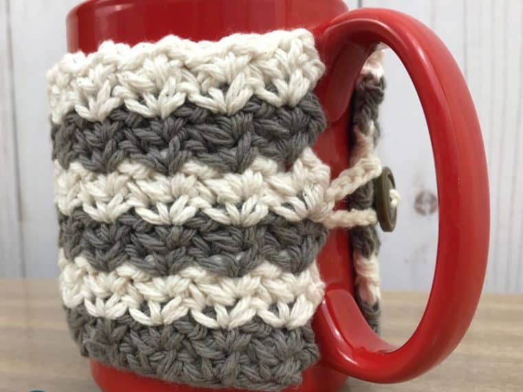 Close up of gray and white crochet coffee cup cozy