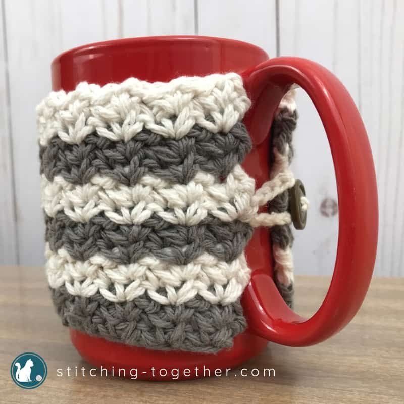 Close up of gray and white crochet coffee cup cozy