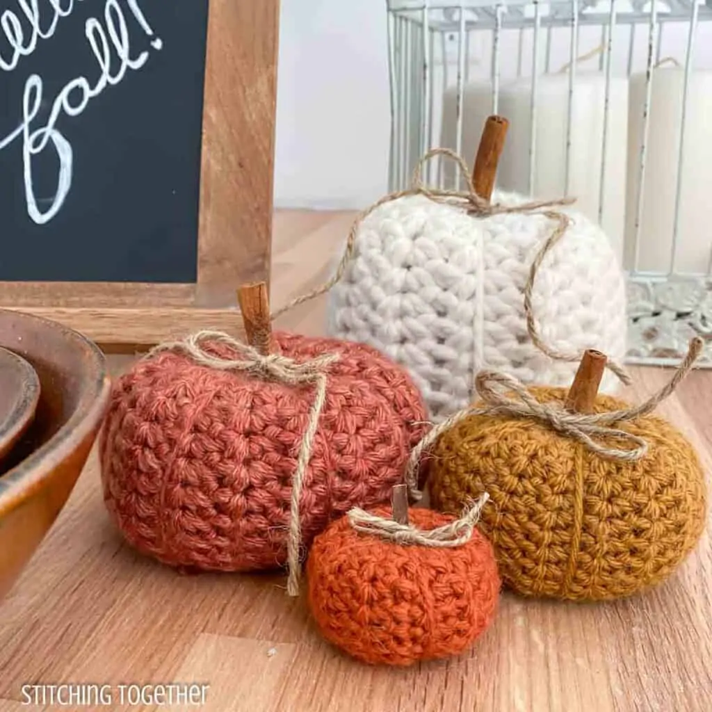 4 crochet pumpkins will surrounded by fall decor
