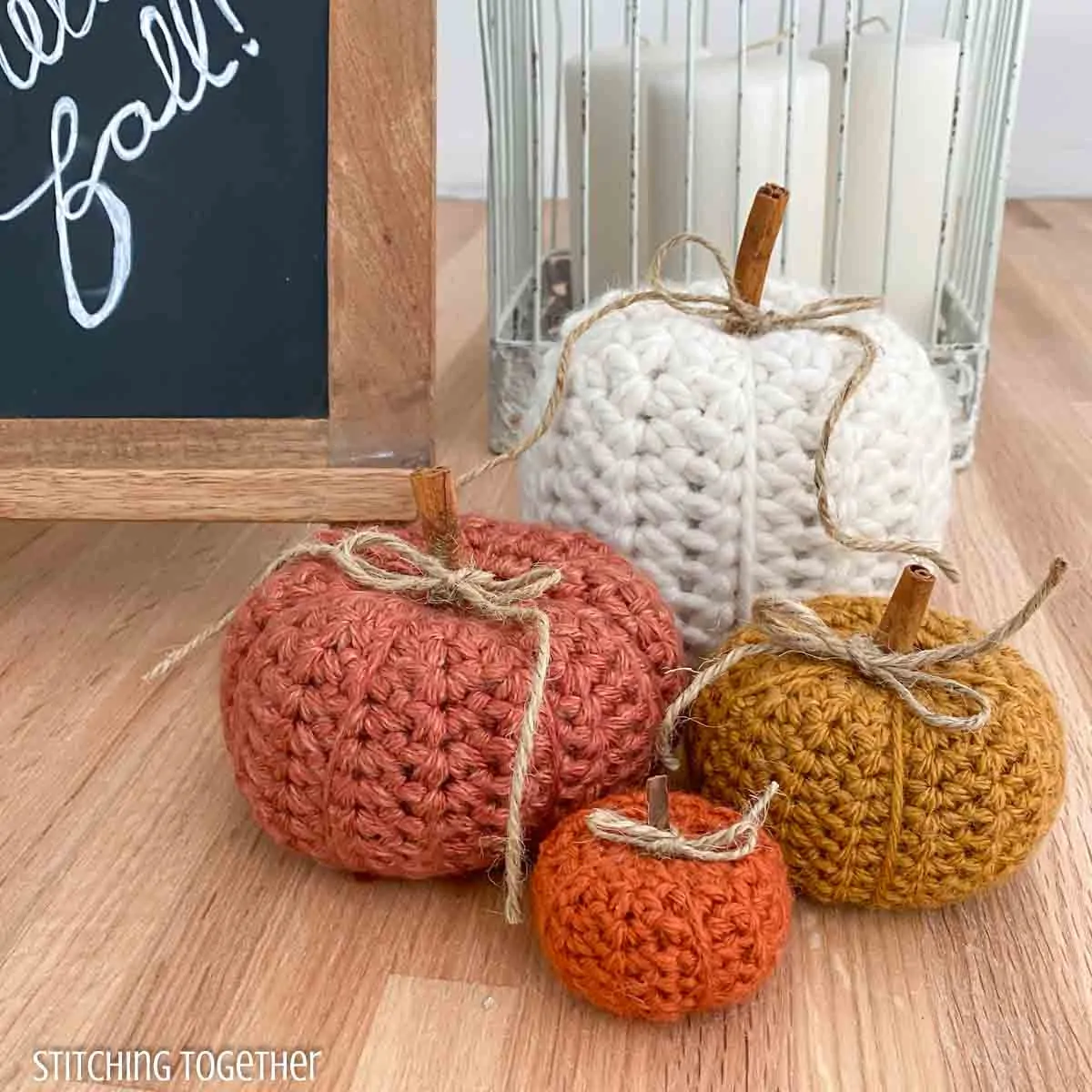 pumpkins crocheted and sitting next to a sign that says hello fall