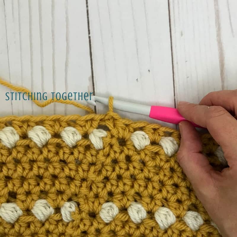 showing hdc join at end of round in mustard yarn