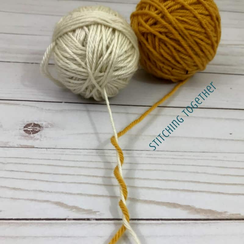 yellow and off white yarn wrapped around each other