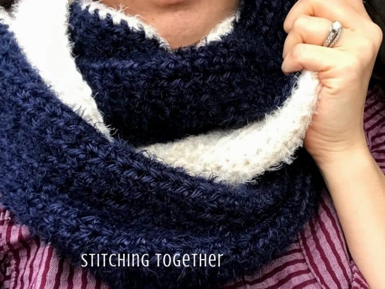 lady wearing luxury crochet infinity scarf that is blue and ivory