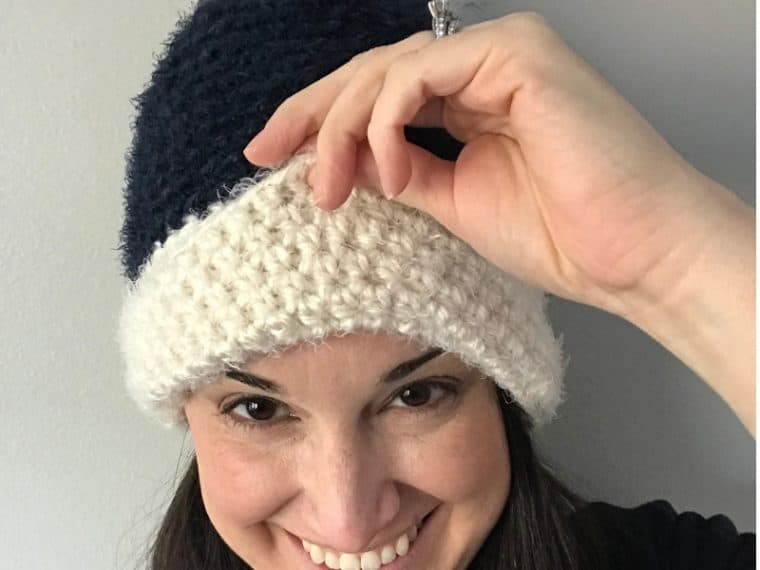 lady holding brim of blue and white crochet beanie