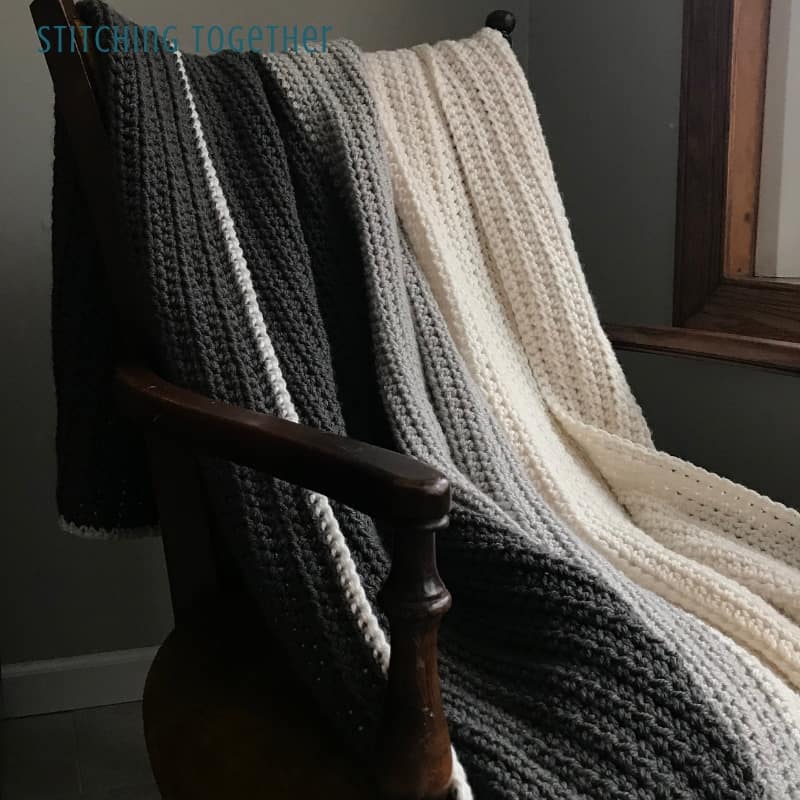 Gray Ombre half double crochet blanket draped on a chair