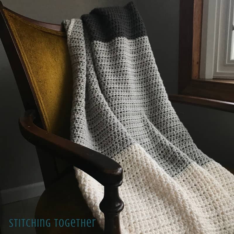 gray striped half double crochet blanket on yellow chair