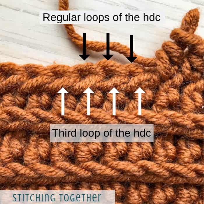 arrows showing the third loop of a half double crochet