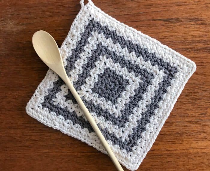 crochet trivet hot pad on table with spoon
