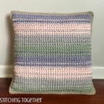 striped crochet throw pillow sitting on floor