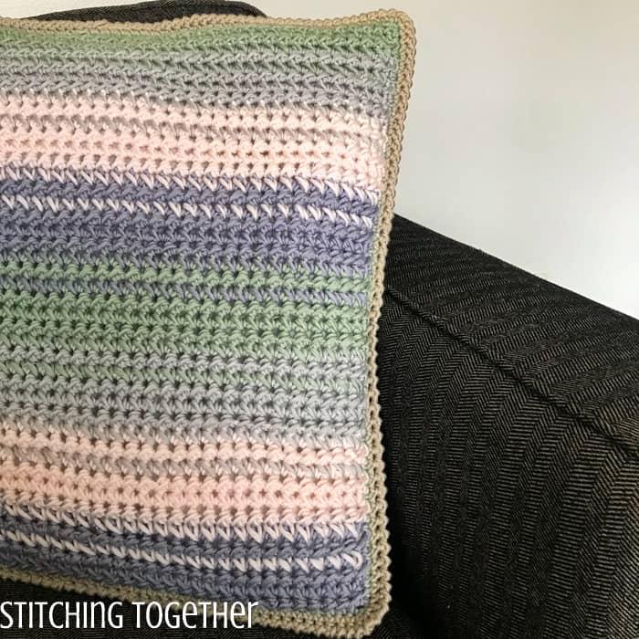 spring colored crochet throw pillow on couch