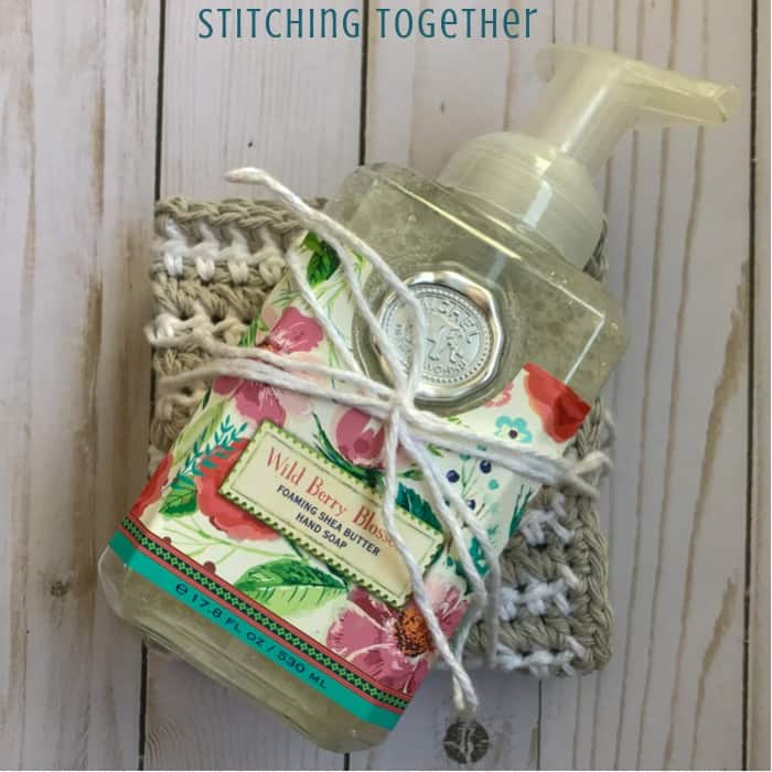 folded crochet dishcloth tied with a bottle of hand soap