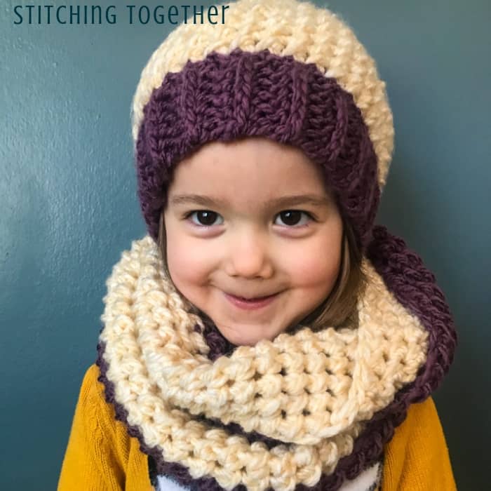 girl wearing purple and white crochet scarf and hat