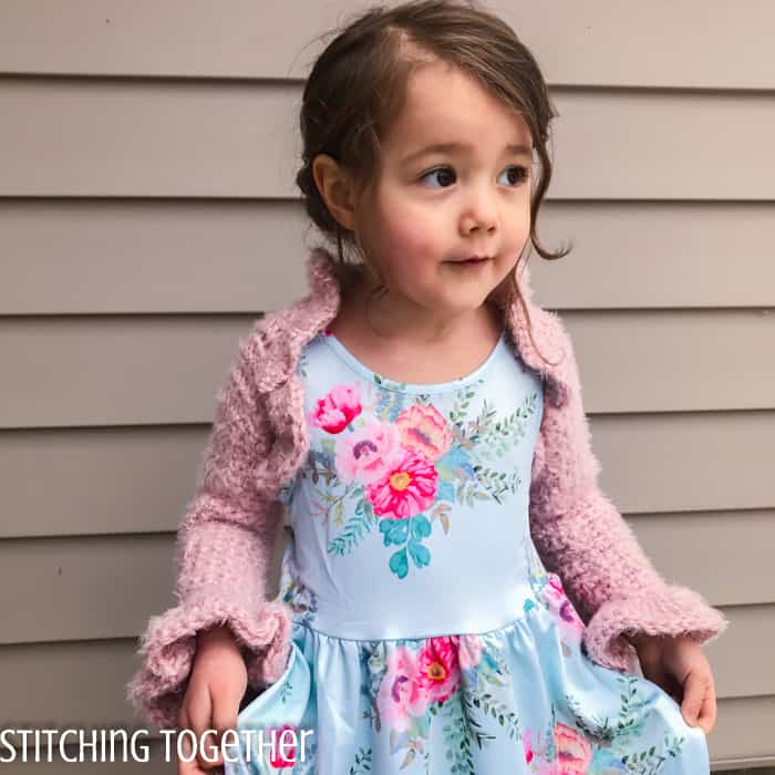 girl wearing pink crochet bolero and dress