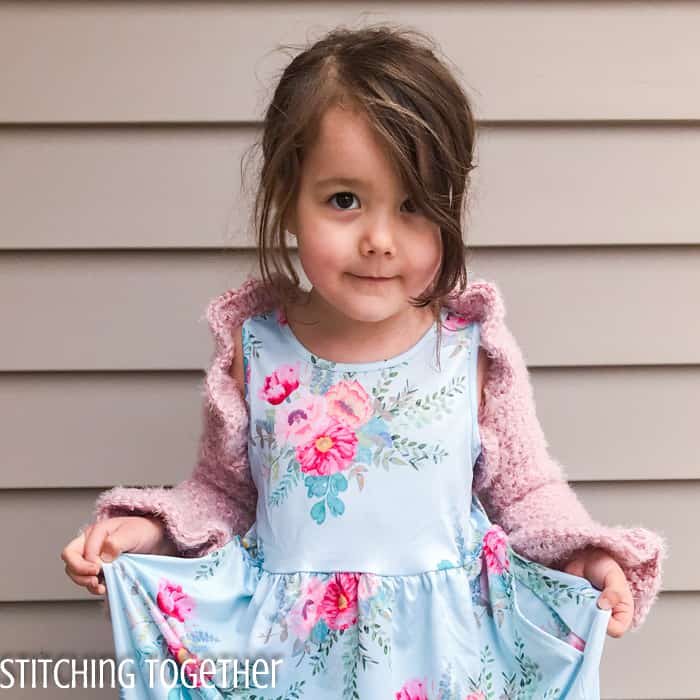 girl wearing pink crochet bolero and flower dress