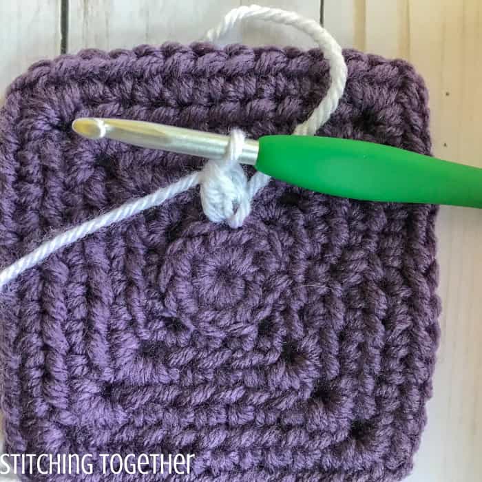 adding crochet petals to a crochet square
