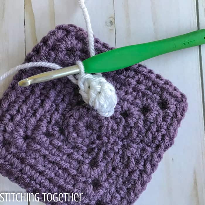 adding crochet petals to a crochet square