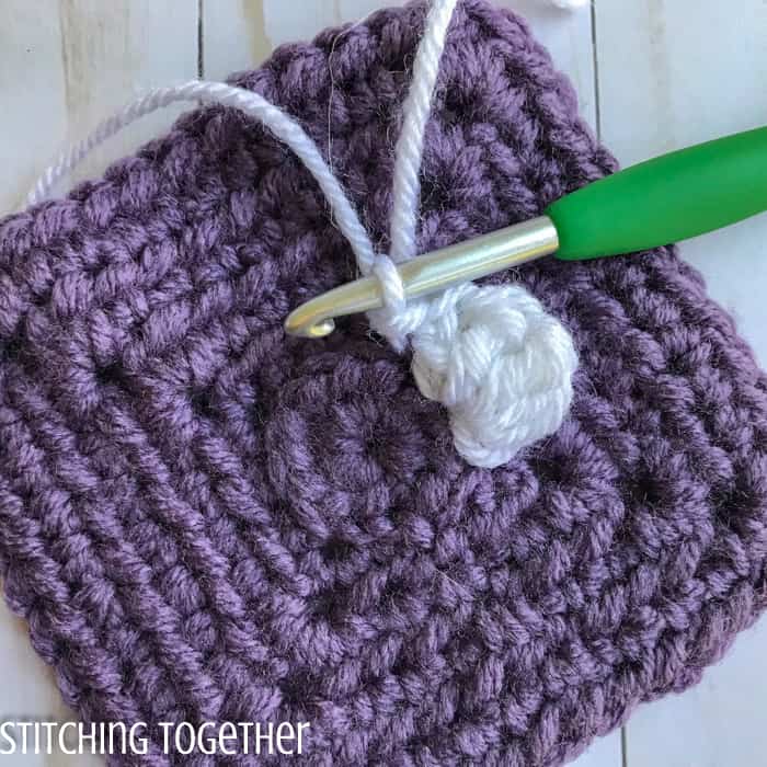 adding crochet petals to a crochet square