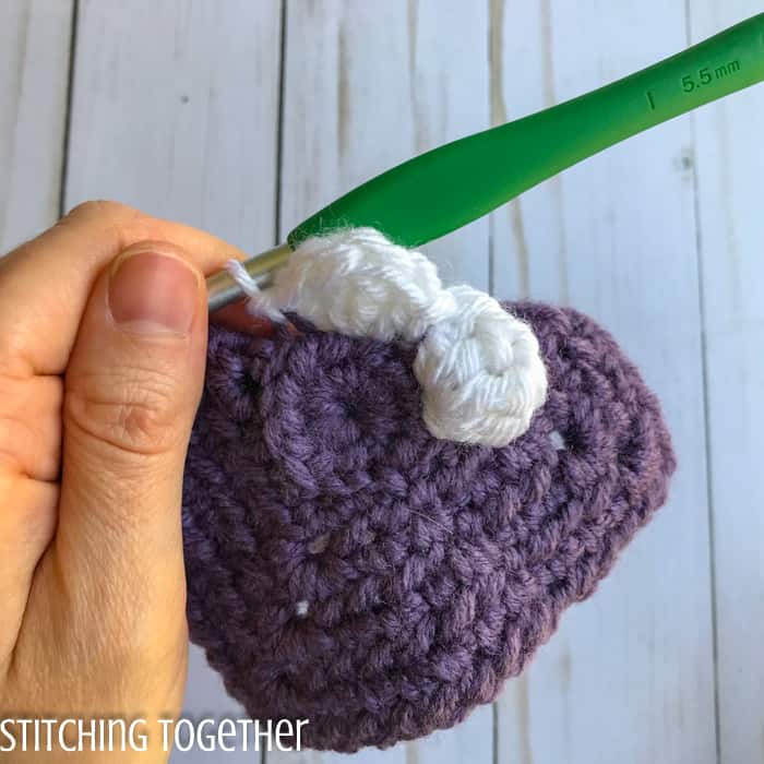adding crochet petals to a crochet square