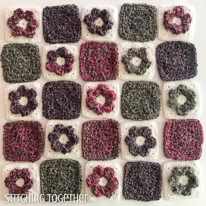 solid granny squares and granny squares with flowers laid out before joining