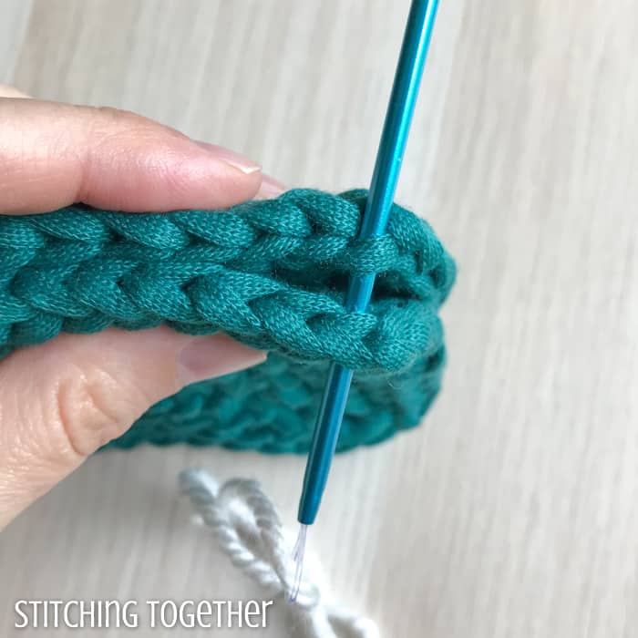 needle poking through 2 crocheted pieces