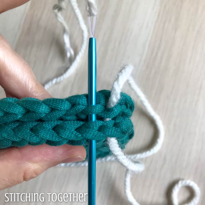 needle poking through 2 crocheted pieces