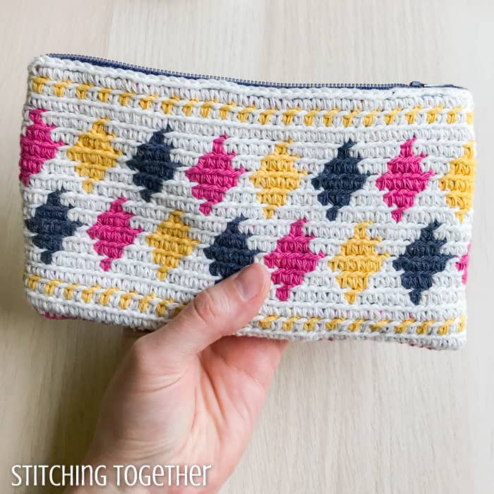 colorful crochet zipper pouch being held