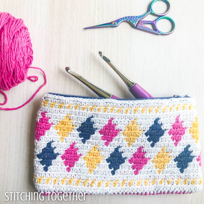 colorful crochet pouch with crochet hooks, yarn, and small scissors