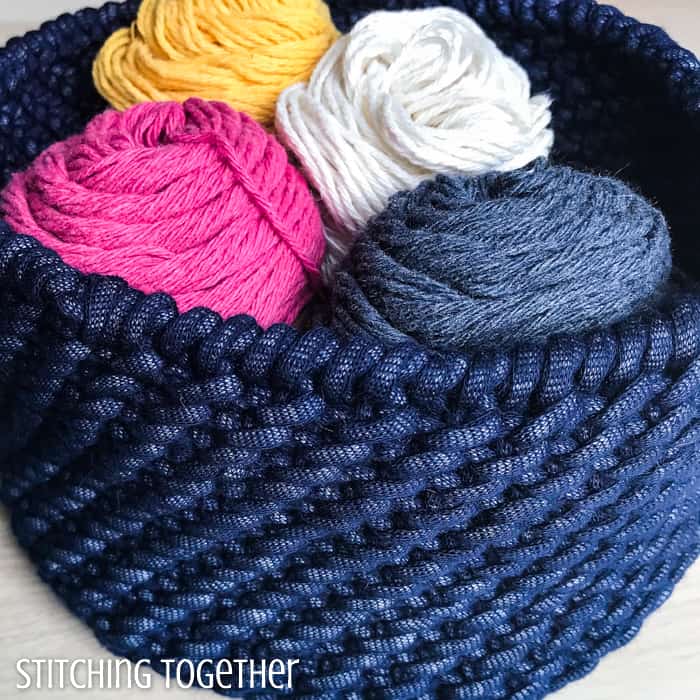 colorful yarn sitting in a bulky crochet basket