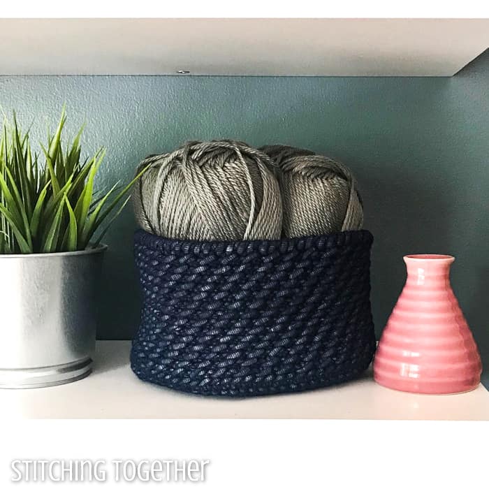 crochet basket filled with yarn sitting on a shelf