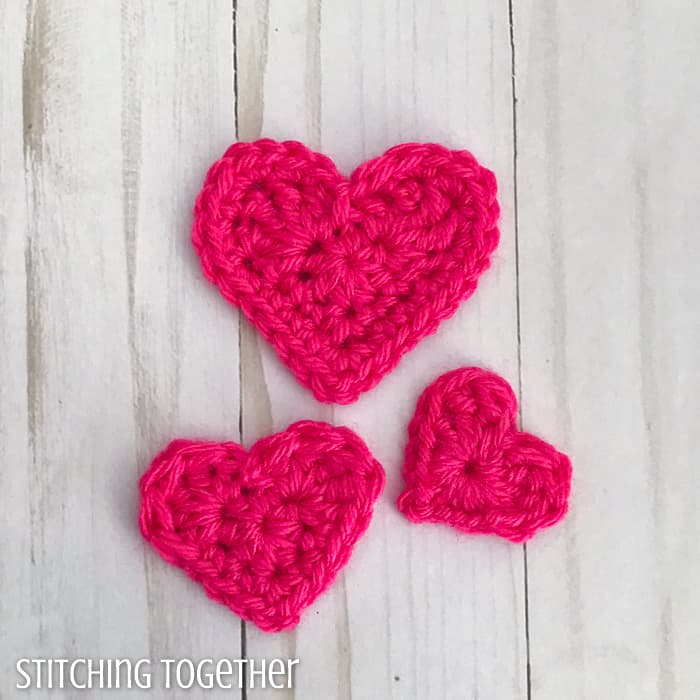 3 pink crochet hearts of different sizes